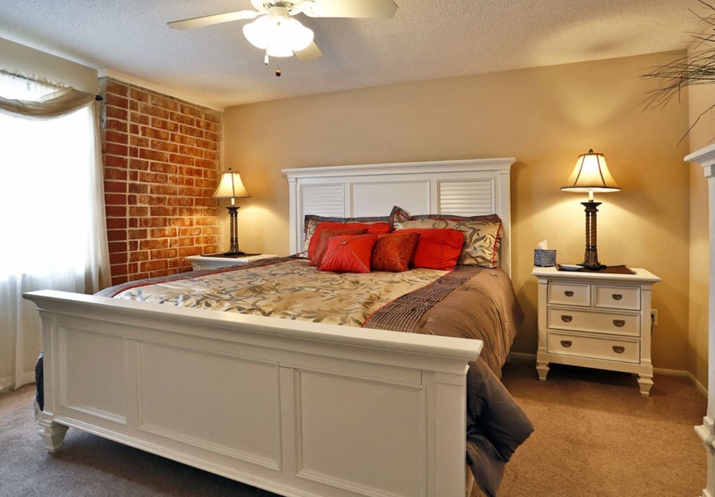 a bedroom with a bed and a brick wall
