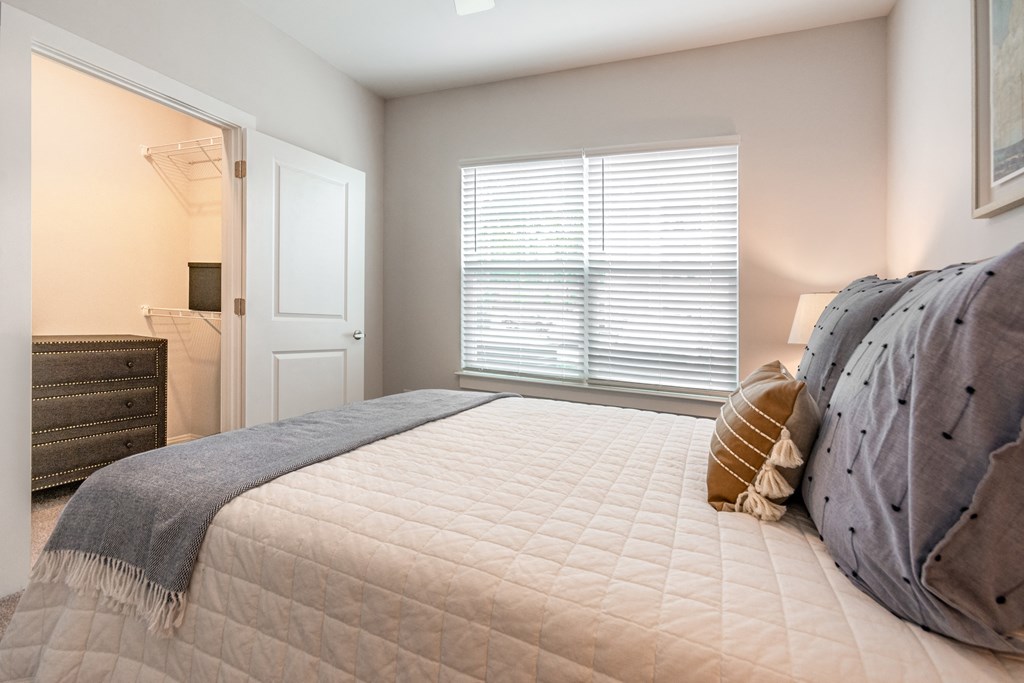 a bedroom with a large bed and a door to a bathroom