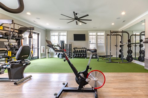 a home gym with exercise equipment and a ceiling fan