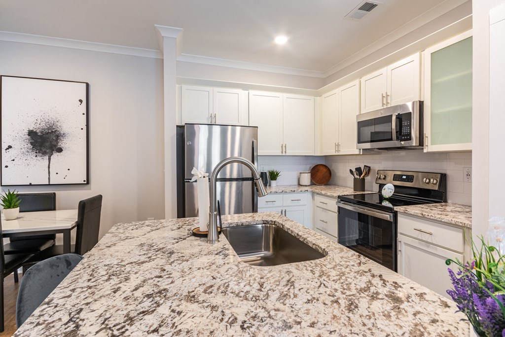 a kitchen with granite counter tops and stainless steel appliances