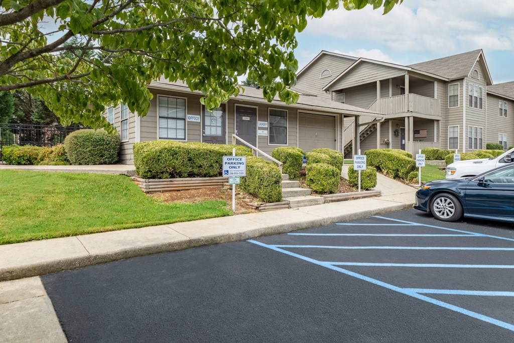 a row of houses in a parking lot with cars parked in front of them