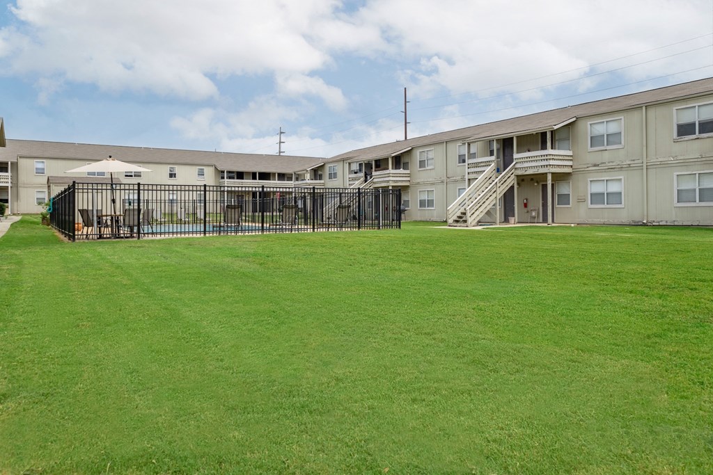 the outlook of an apartment building with a large green lawn
