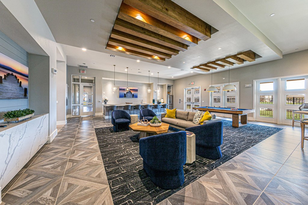 a clubhouse with couches and chairs and a pool table