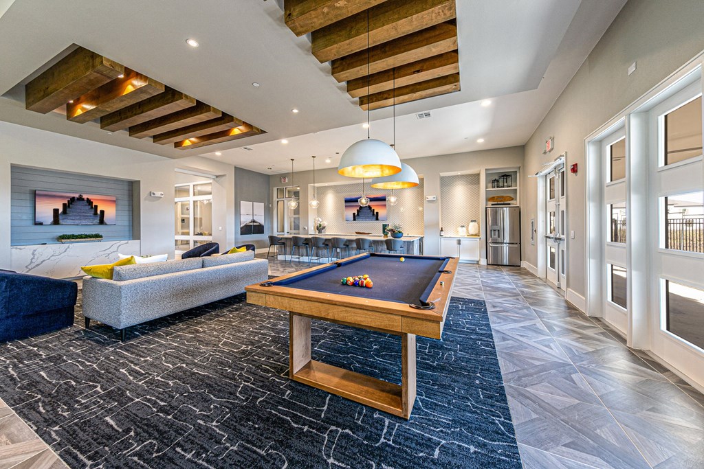 a game room with a pool table and couches