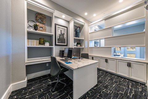 a home office with a white desk and shelves