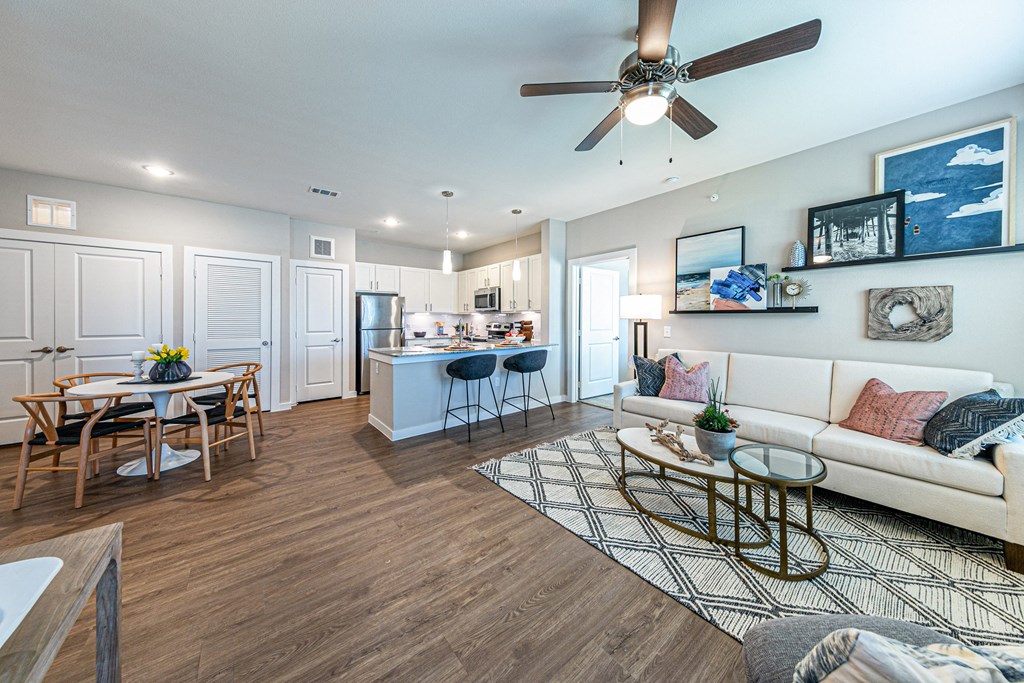 a living room and kitchen with a ceiling fan