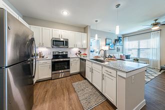 a large kitchen with stainless steel appliances and white cabinets