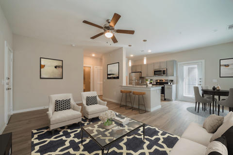 an open living room and kitchen with a ceiling fan