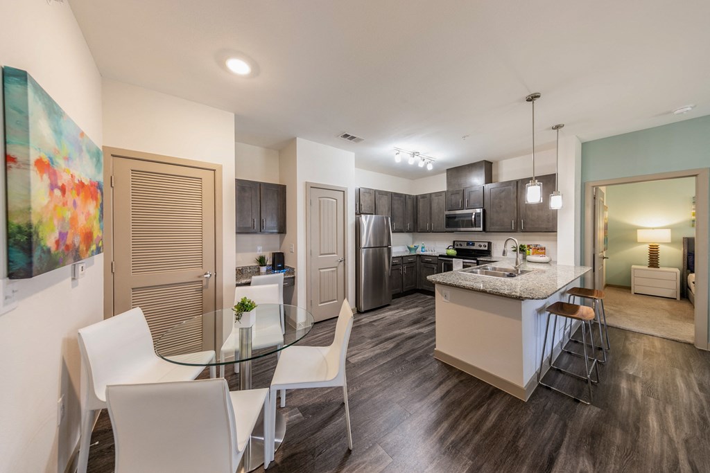 a kitchen and dining room with a glass table and chairs