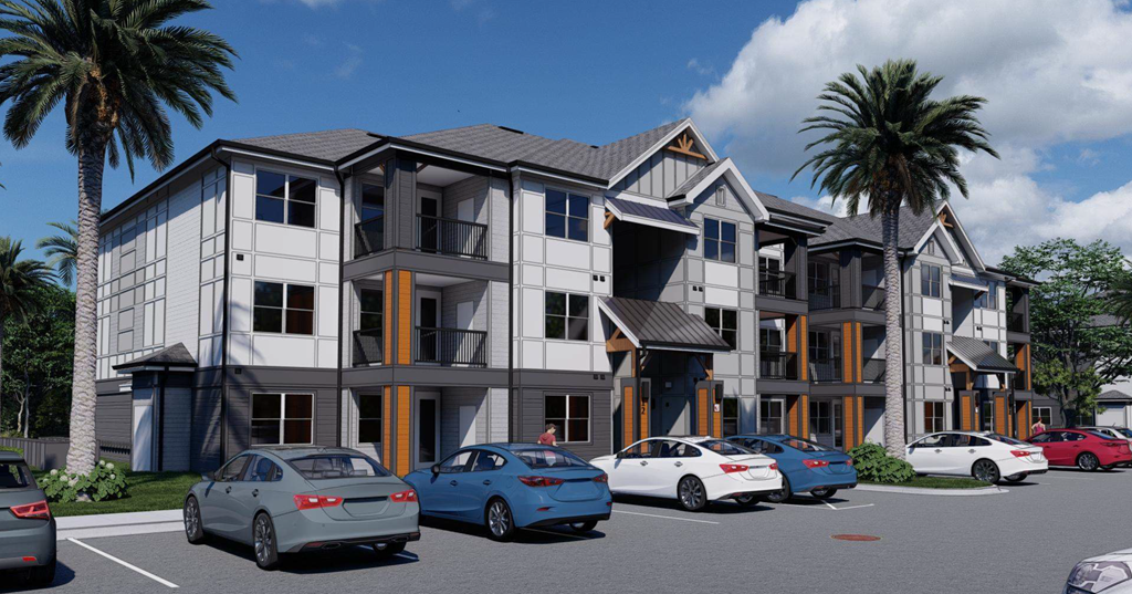 A modern apartment complex with cars parked in front.
