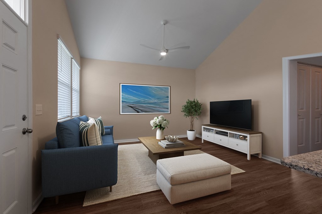 A living room with a blue couch, a coffee table, and a television.