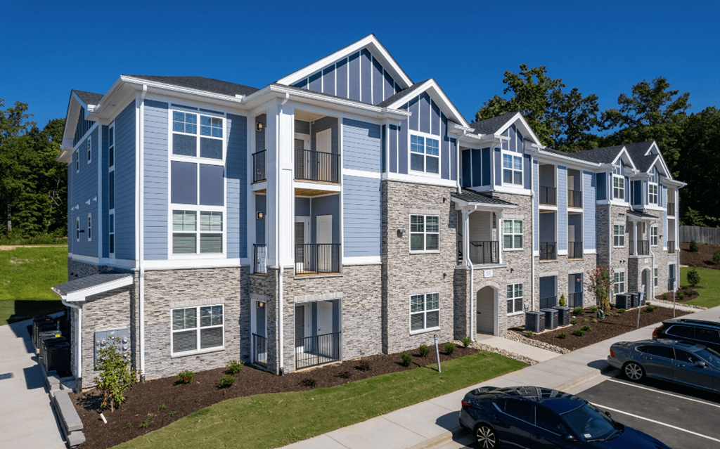 an apartment building with cars parked in front of it