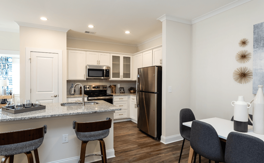 a kitchen and dining room with stainless steel appliances and a granite counter top
