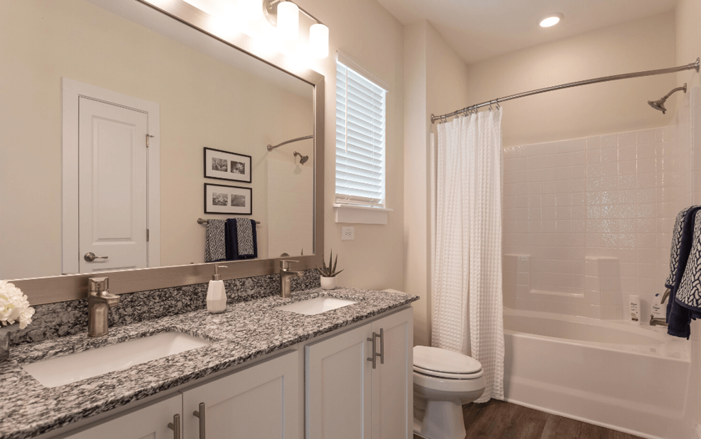 a bathroom with two sinks and a shower and a toilet