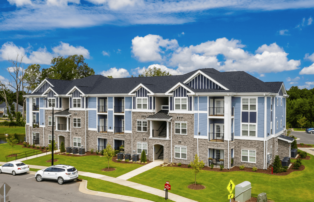 an apartment building with cars parked in front of it