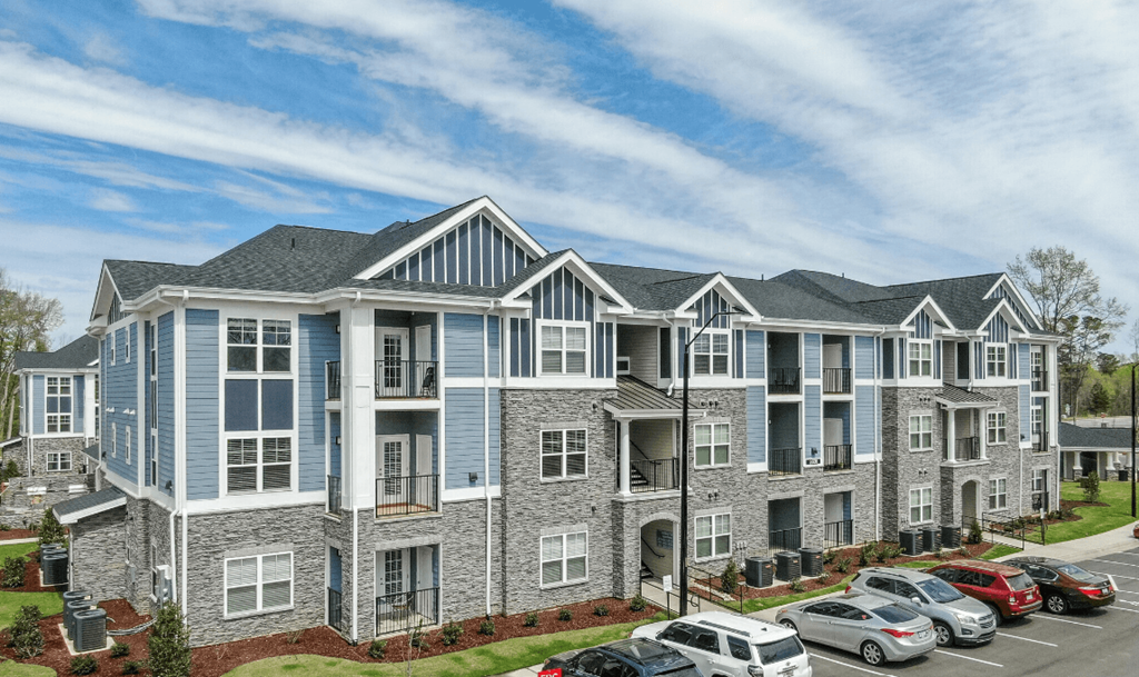 an aerial view of an apartment building with a parking lot