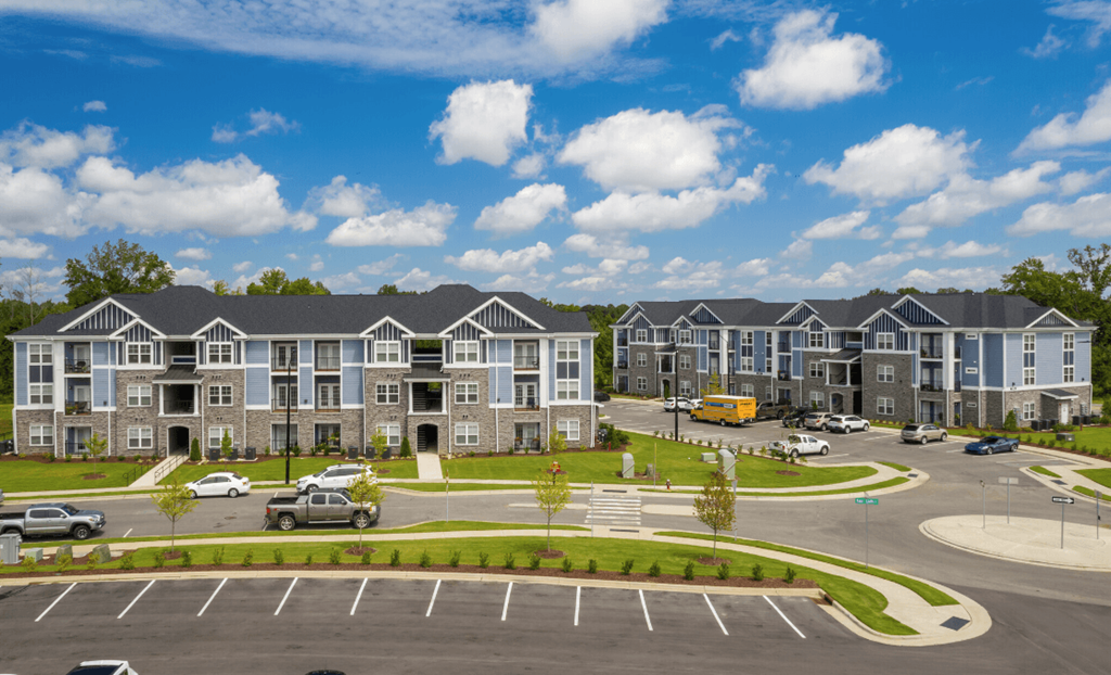 an aerial view of an apartment complex with a parking lot