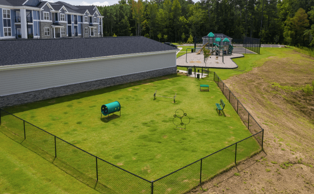 a backyard park with a playground and a large house