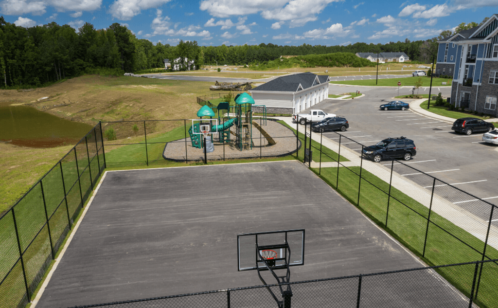 an aerial view of a basketball court and playground in a parking lot