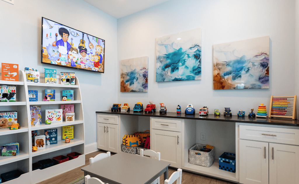 a play room with toys and paintings on the wall