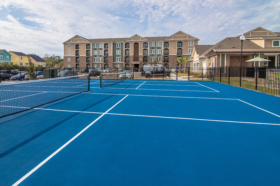 two tennis courts with apartments in the background