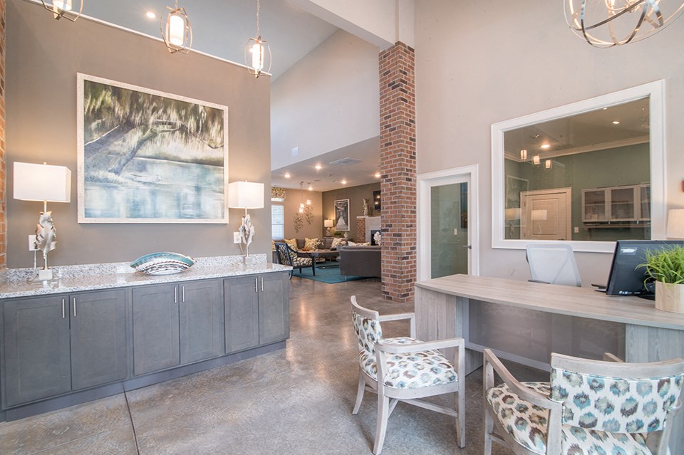 a lobby with a counter and chairs and a living room