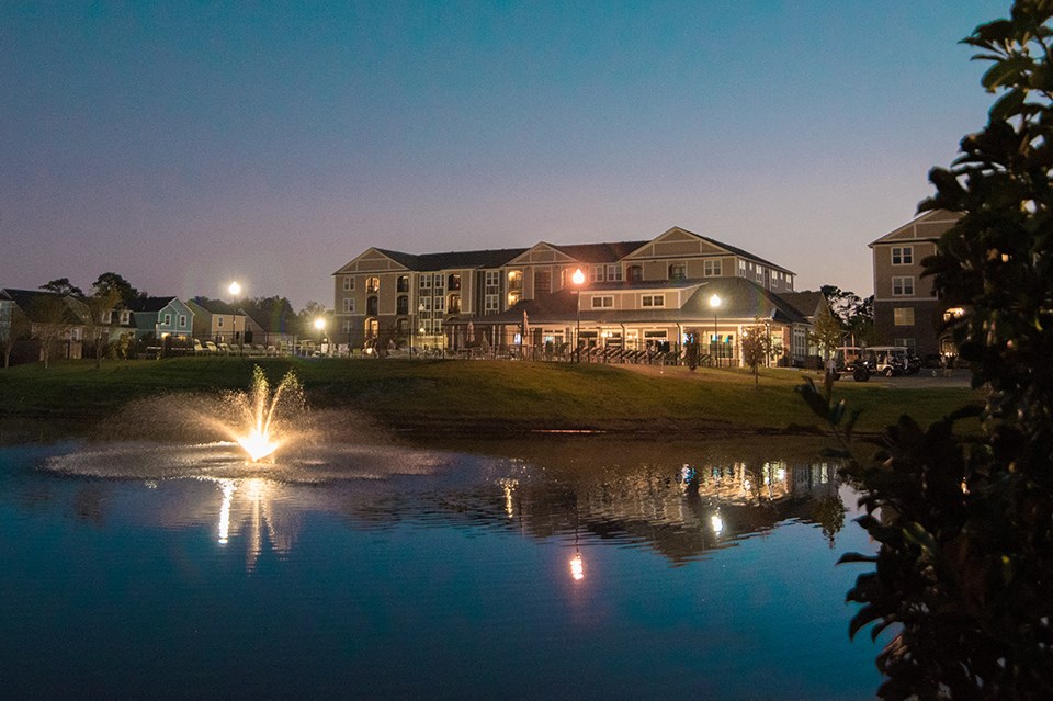 a view of a lake with buildings in the background at night