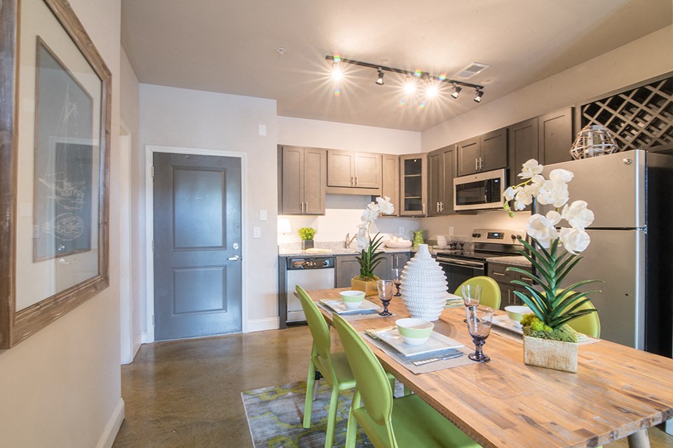 an open kitchen and dining room with a wooden table and chairs