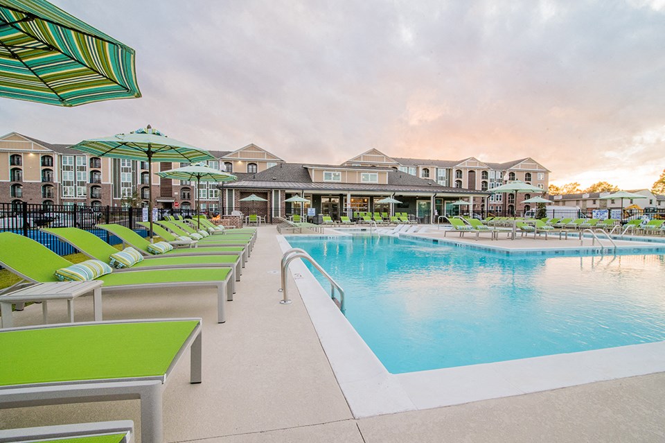 a swimming pool with lounge chairs and umbrellas at the resort