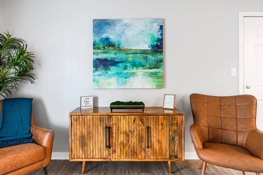 a living room with a cabinet and a painting on the wall