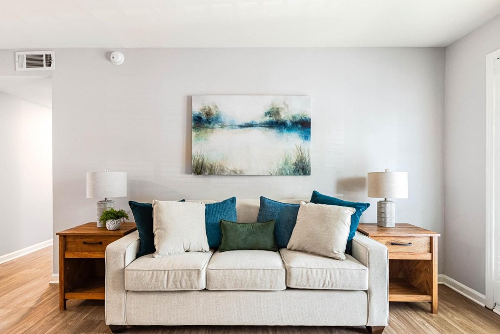 a living room with a couch and a painting on the wall