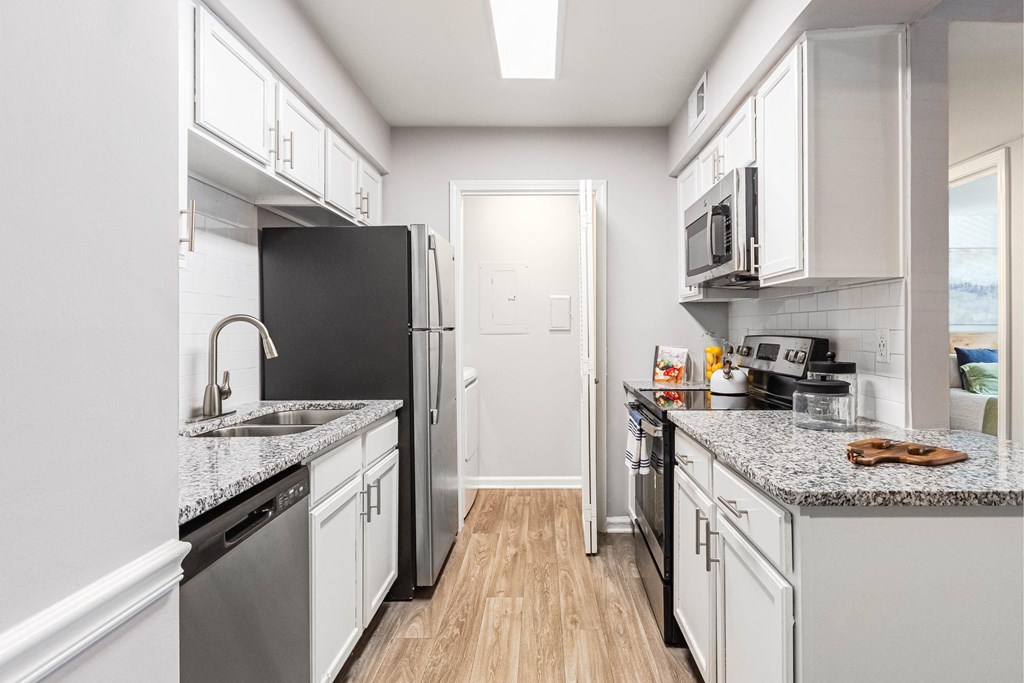 a kitchen with white cabinets and stainless steel appliances
