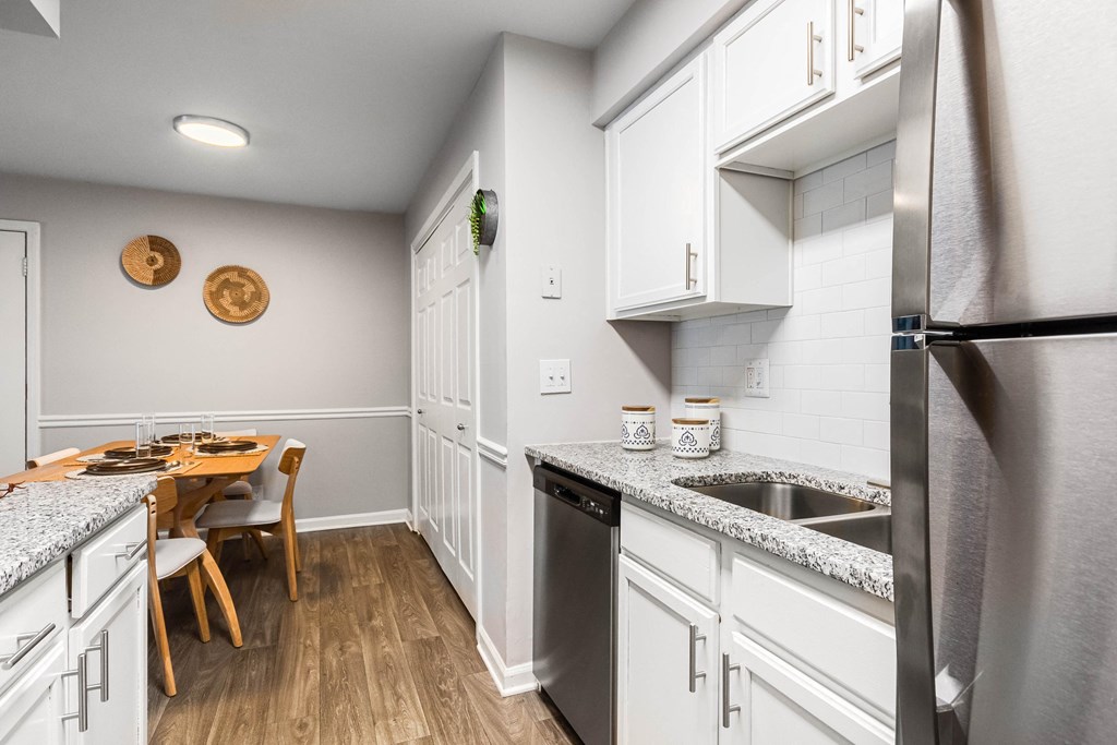 a kitchen with white cabinets and stainless steel appliances