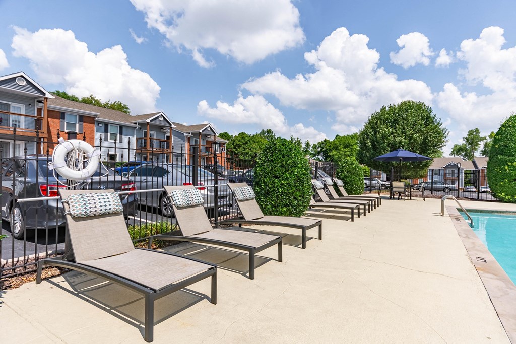 a row of lounge chairs next to a swimming pool