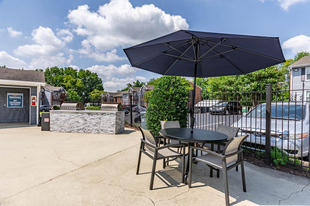 a patio with a table with chairs and an umbrella