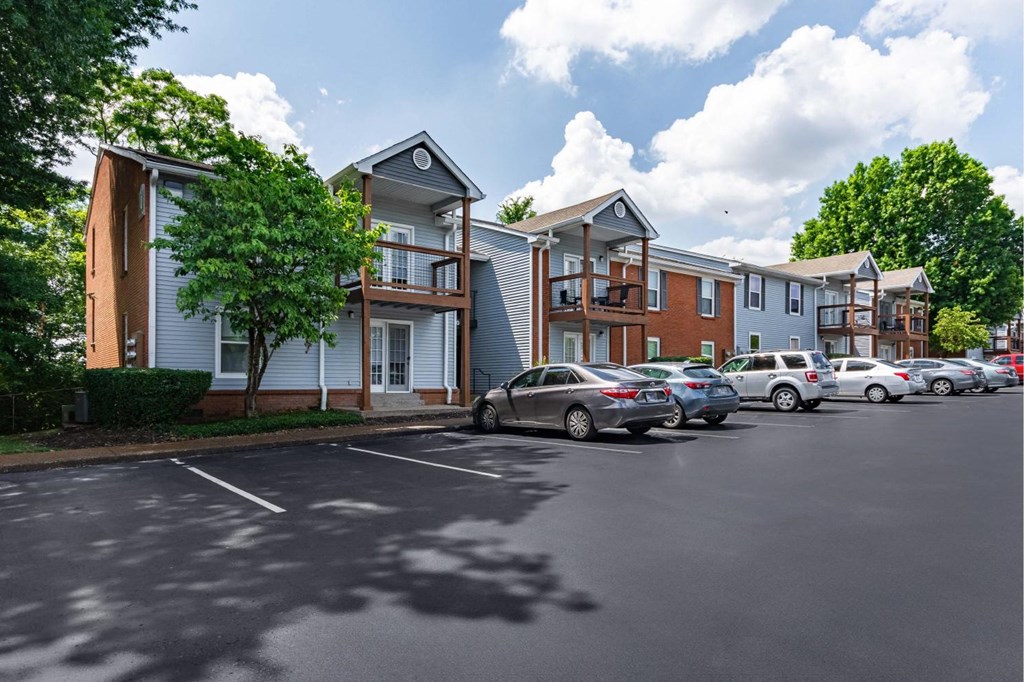 a parking lot with cars parked in front of buildings