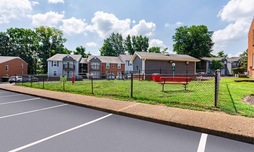 a fenced in park with houses in the background