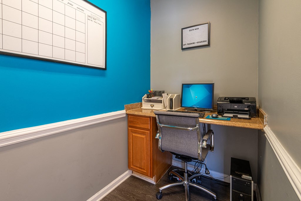 a home office with a computer and printer on a desk