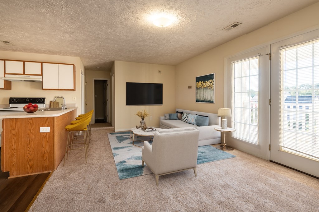 a living room with a couch and a chair and a kitchen
