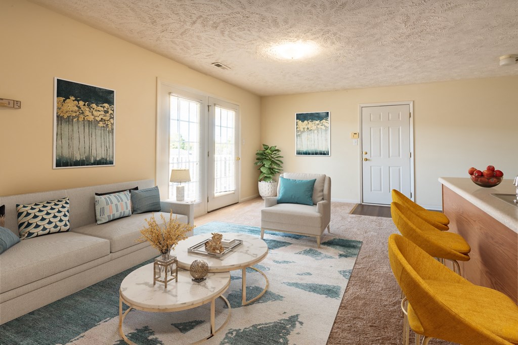 a living room with a couch and chairs and a coffee table
