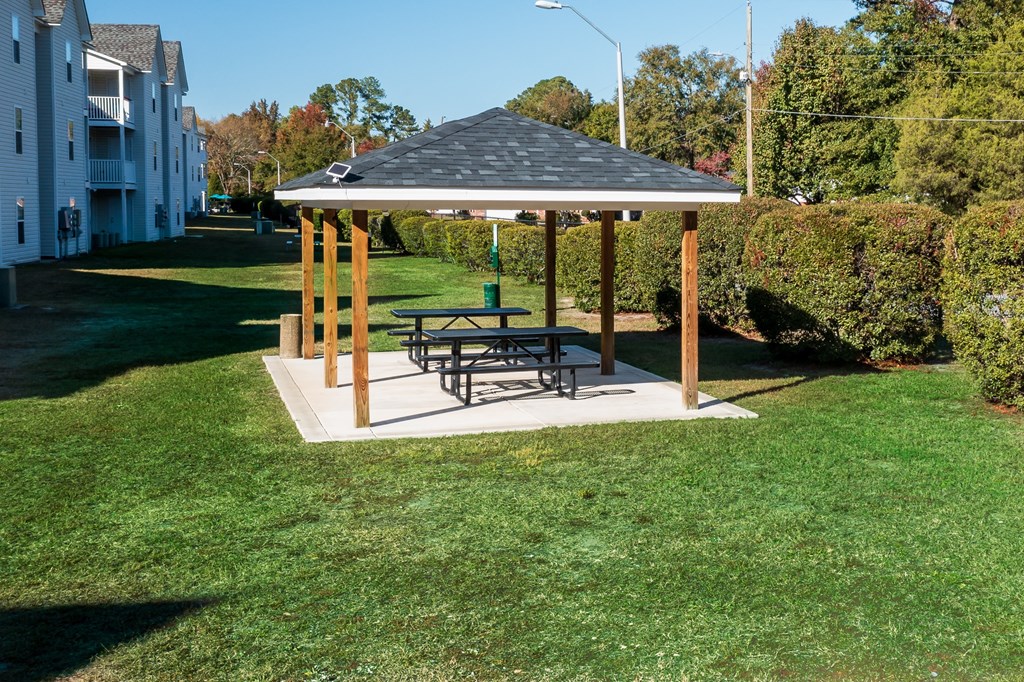 a gazebo with a picnic table in a yard