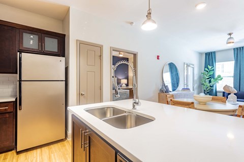 a white kitchen with a stainless steel refrigerator and a sink