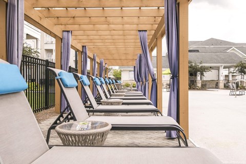 a row of lounge chairs on the porch of a building