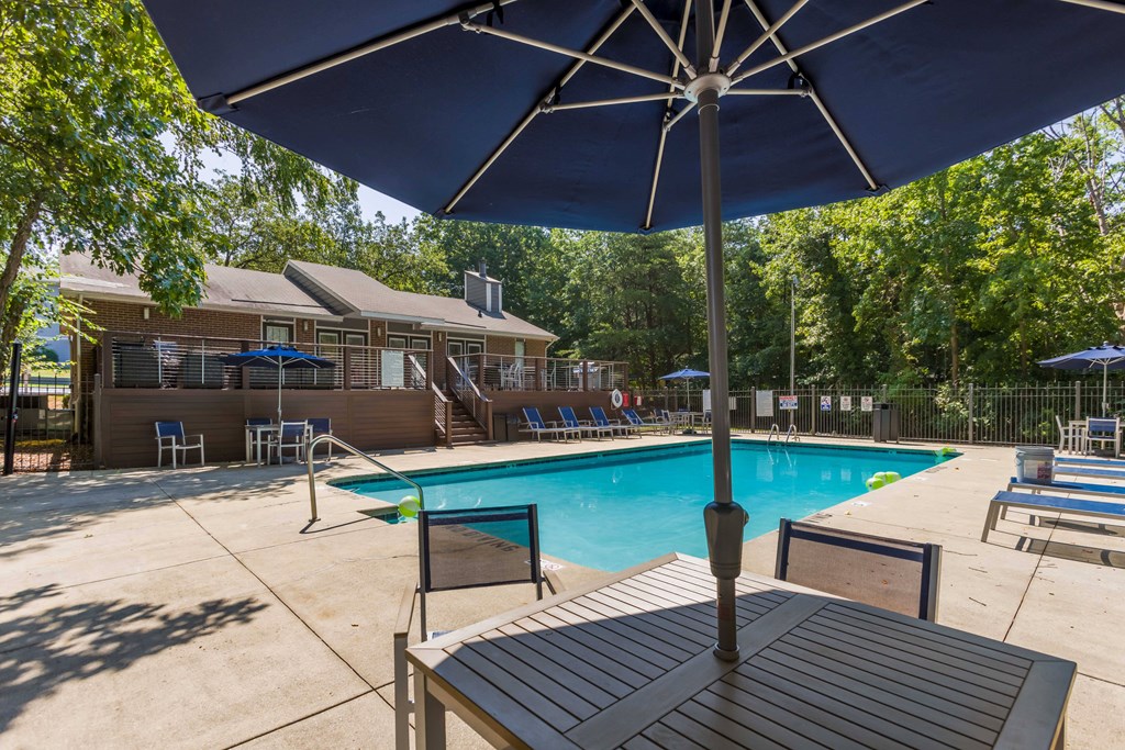 our apartments have a swimming pool and table with an umbrella