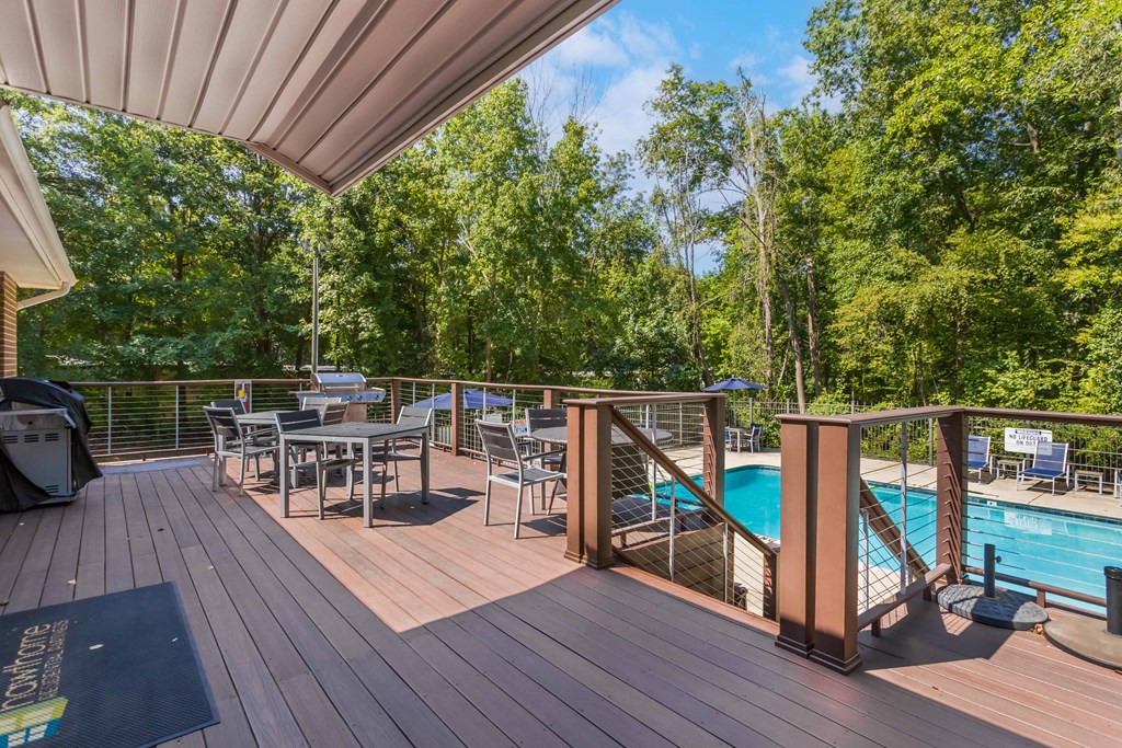 a large deck with tables and chairs and a swimming pool