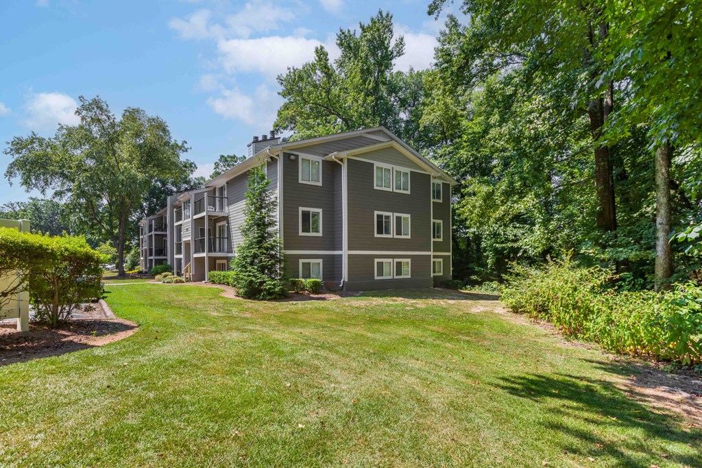 exterior view of the apartment building with grass and trees