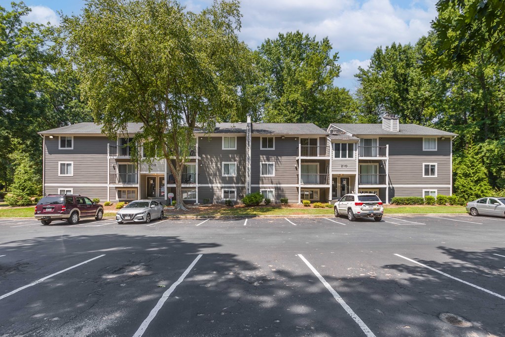 an apartment building with cars parked in a parking lot