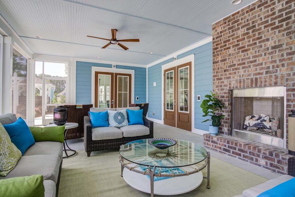 a living room with a brick fireplace and a glass coffee table