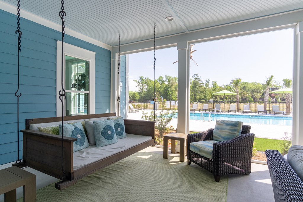 a porch swing with a view of a swimming pool