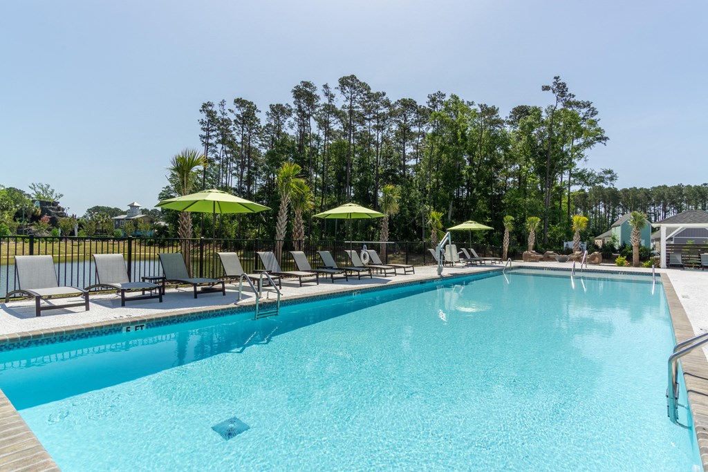 a swimming pool with chairs and umbrellas at the resort